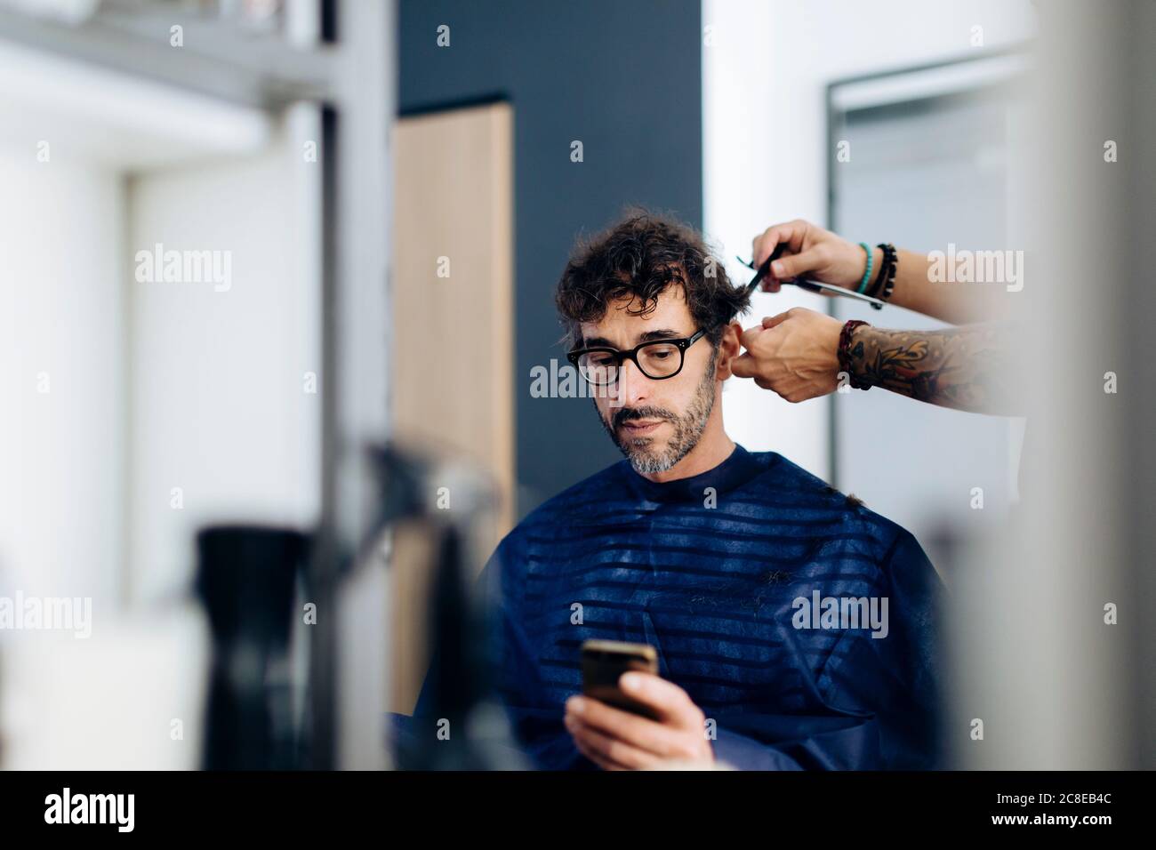 Coiffeur coupant les cheveux de l'homme au salon Banque D'Images