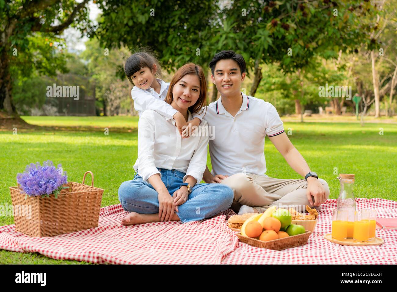 Famille des adolescents asiatiques bonne vacances pique-nique moment dans le parc avec père, mère et fille regardant la caméra et sourire à heureux passer des vacances à Banque D'Images