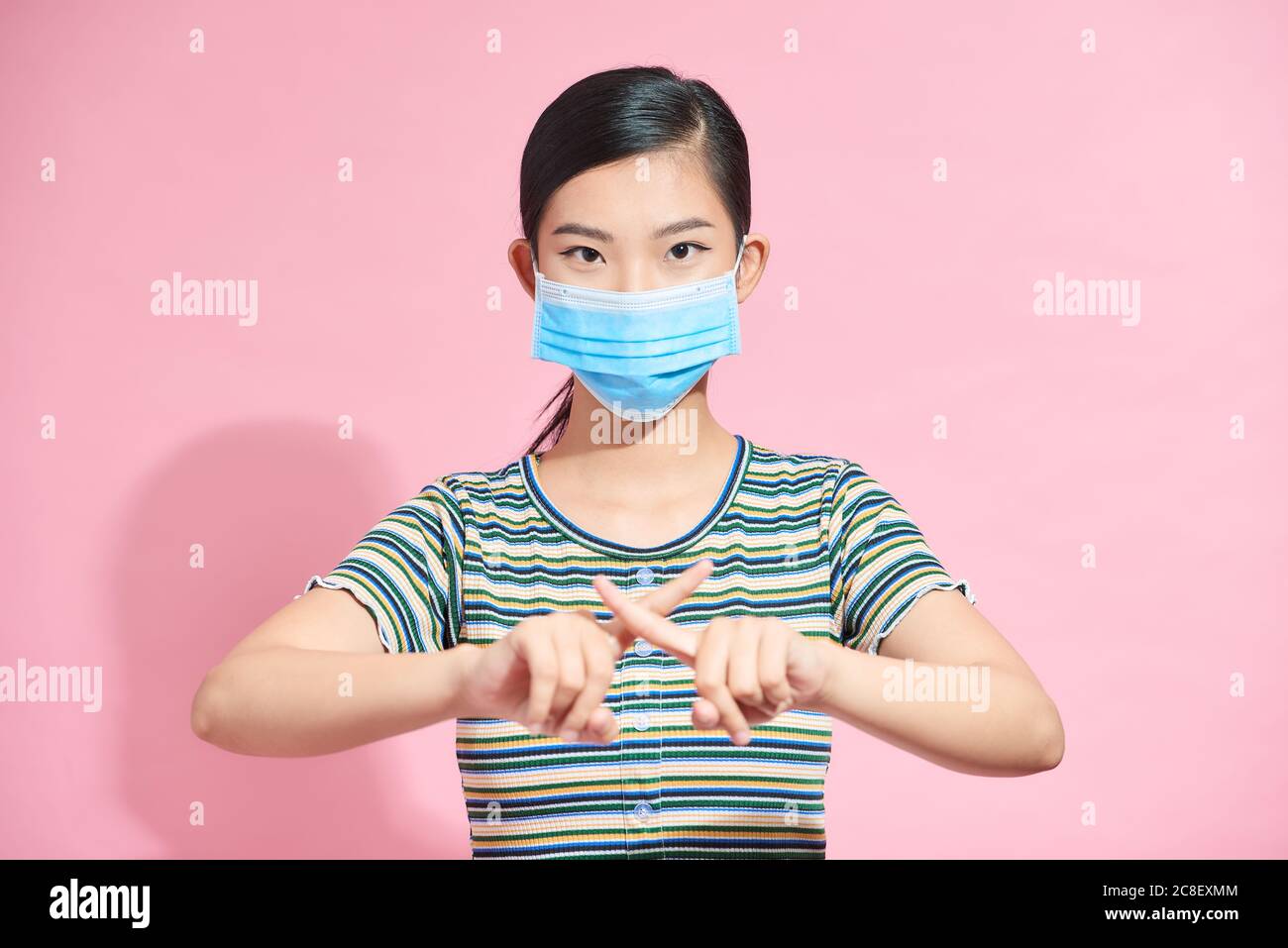 Beaterfull femme en visage masque chirurgical montrer stop par le doigt, geste pour arrêter le virus corona. Banque D'Images