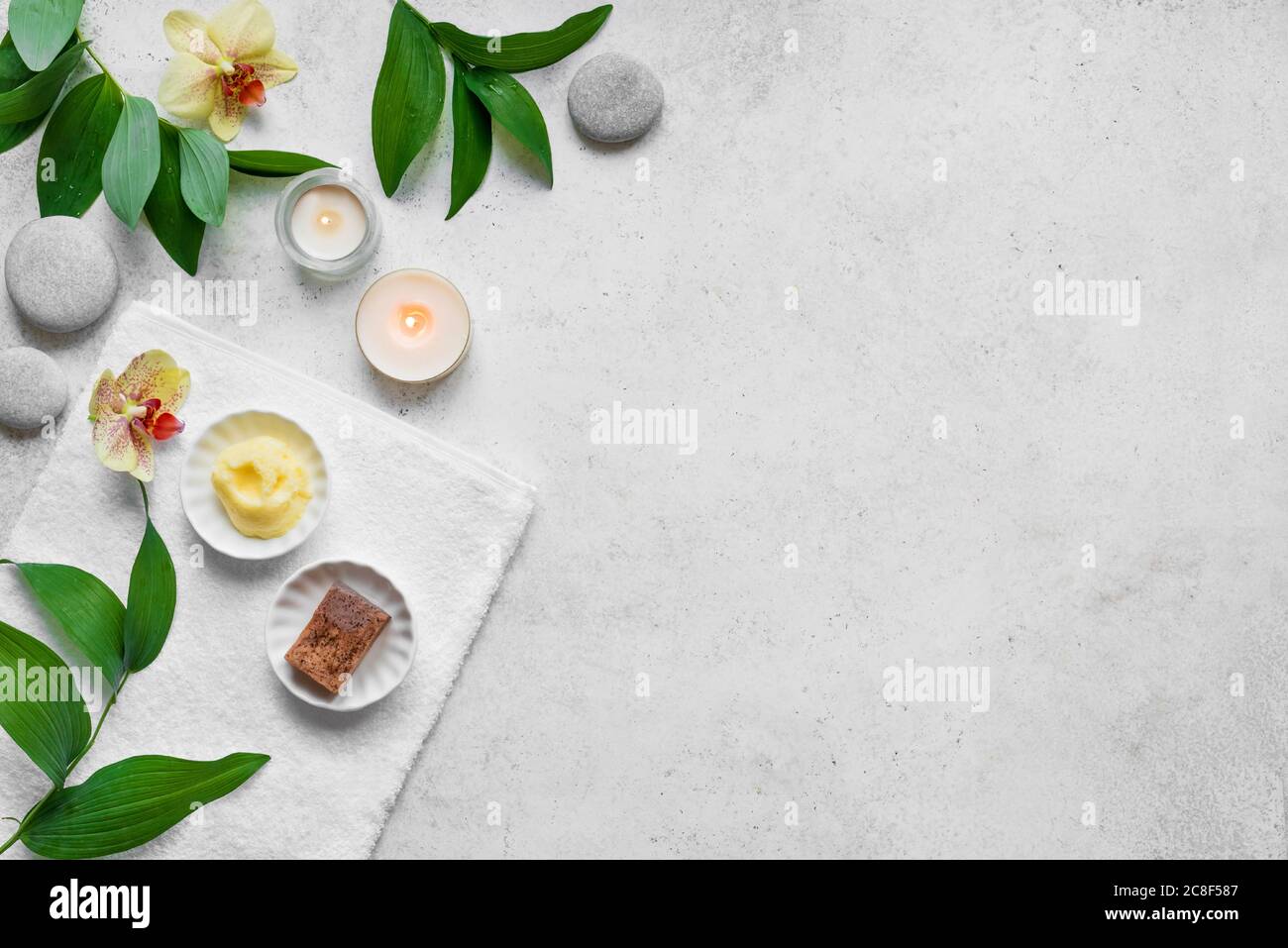 Concept spa sur fond de pierre blanche, feuilles tropicales, fleurs, bougies, pierres grises zen, vue sur le dessus, espace copie. Temps de détente, rituel spa. Banque D'Images