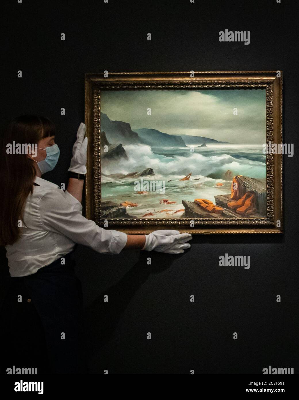 Un assistant de galerie détient l'un des triptyques, Mediterranean Sea View by Banksy 2017, des peintures à l'huile retravaillées dans des cadres d'artistes en trois parties avec une estimation de 800k-1,2 millions de GBP lors d'un aperçu de presse à Sotheby's à Londres, en prévision de leur vente de « Rembrandt à Richter » le 28 juillet. Banque D'Images