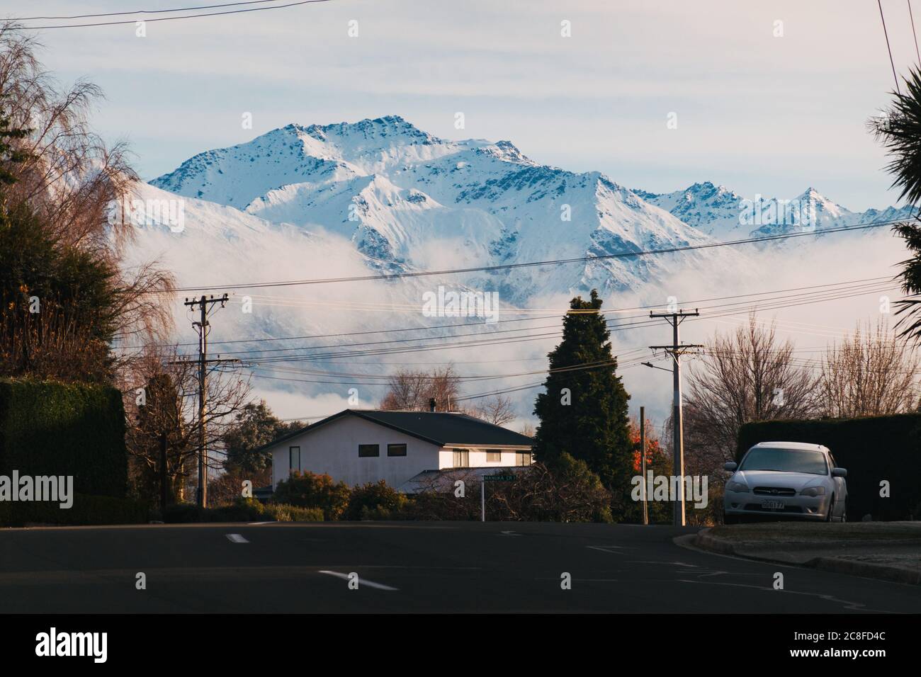 Les Alpes du Sud enneigées surpassent une banlieue tranquille de Wanaka lors d'une matinée hivernale glacielle dans l'île du Sud de la Nouvelle-Zélande Banque D'Images