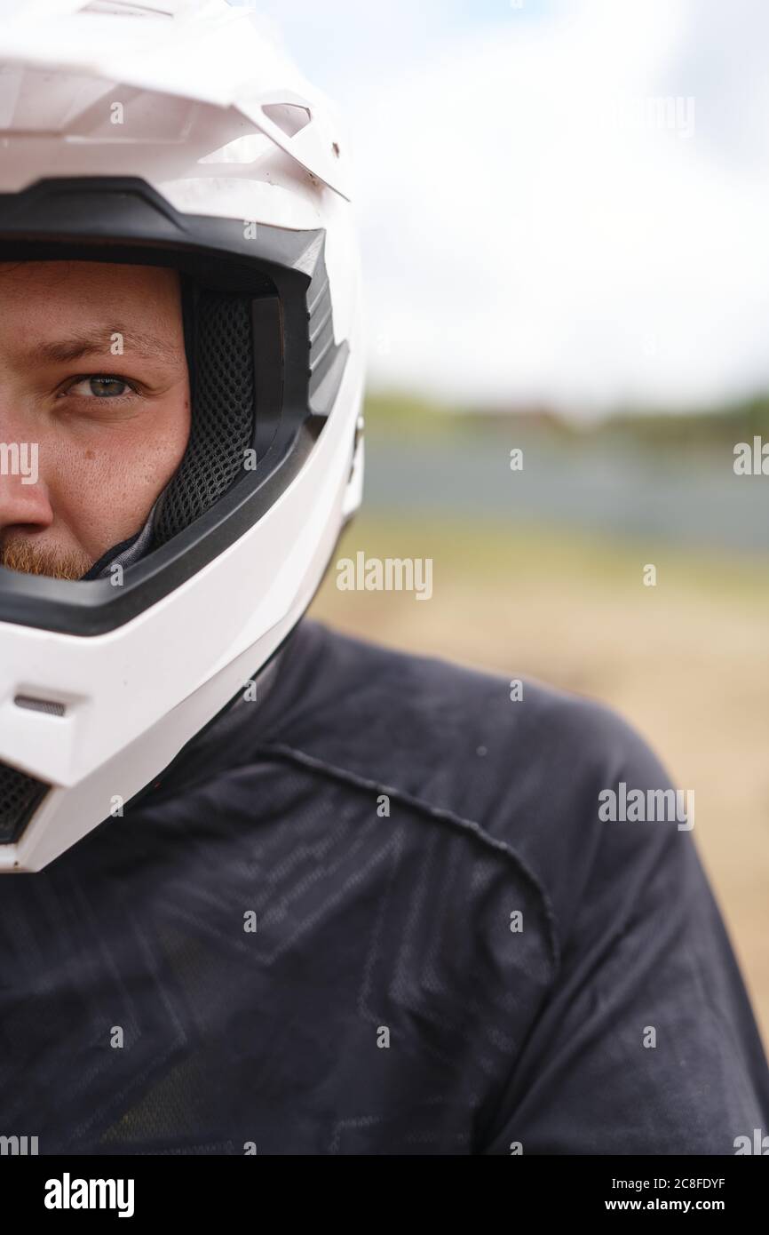Portrait d'un automobiliste violent dans un casque et une veste debout à l'extérieur Banque D'Images