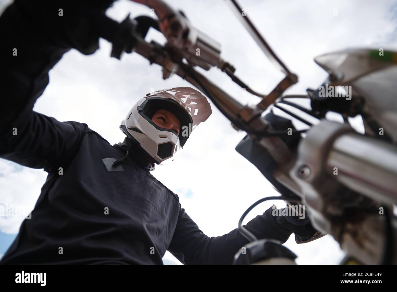 Vue en dessous de l'homme concentré dans le casque de maintien du levier tout en étant prêt pour la course de moto Banque D'Images