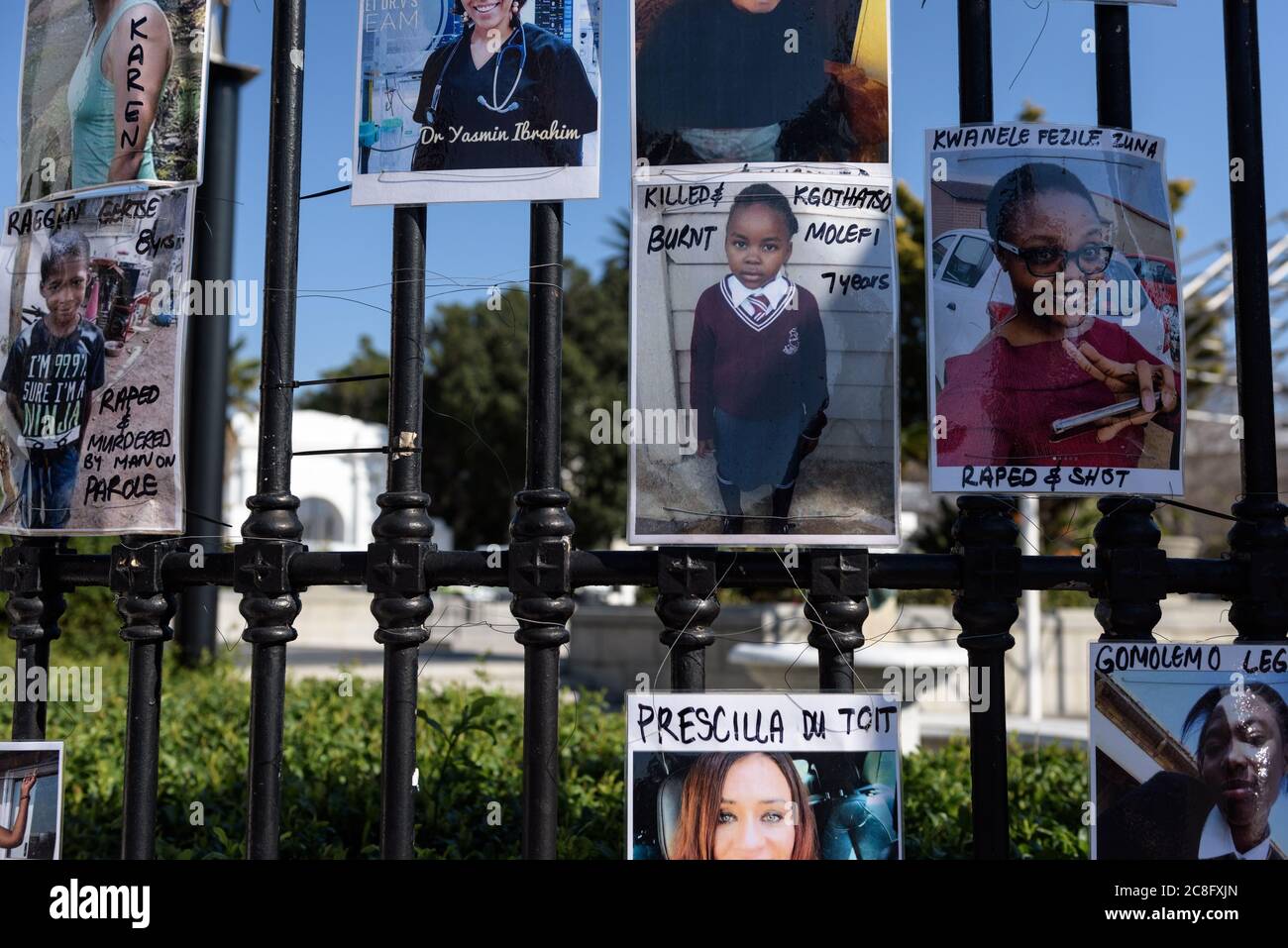 Une galerie de femmes et d'enfants assassinés dans des crimes de violence sexiste est suspendue sur les rails du Parlement sud-africain du Cap Banque D'Images