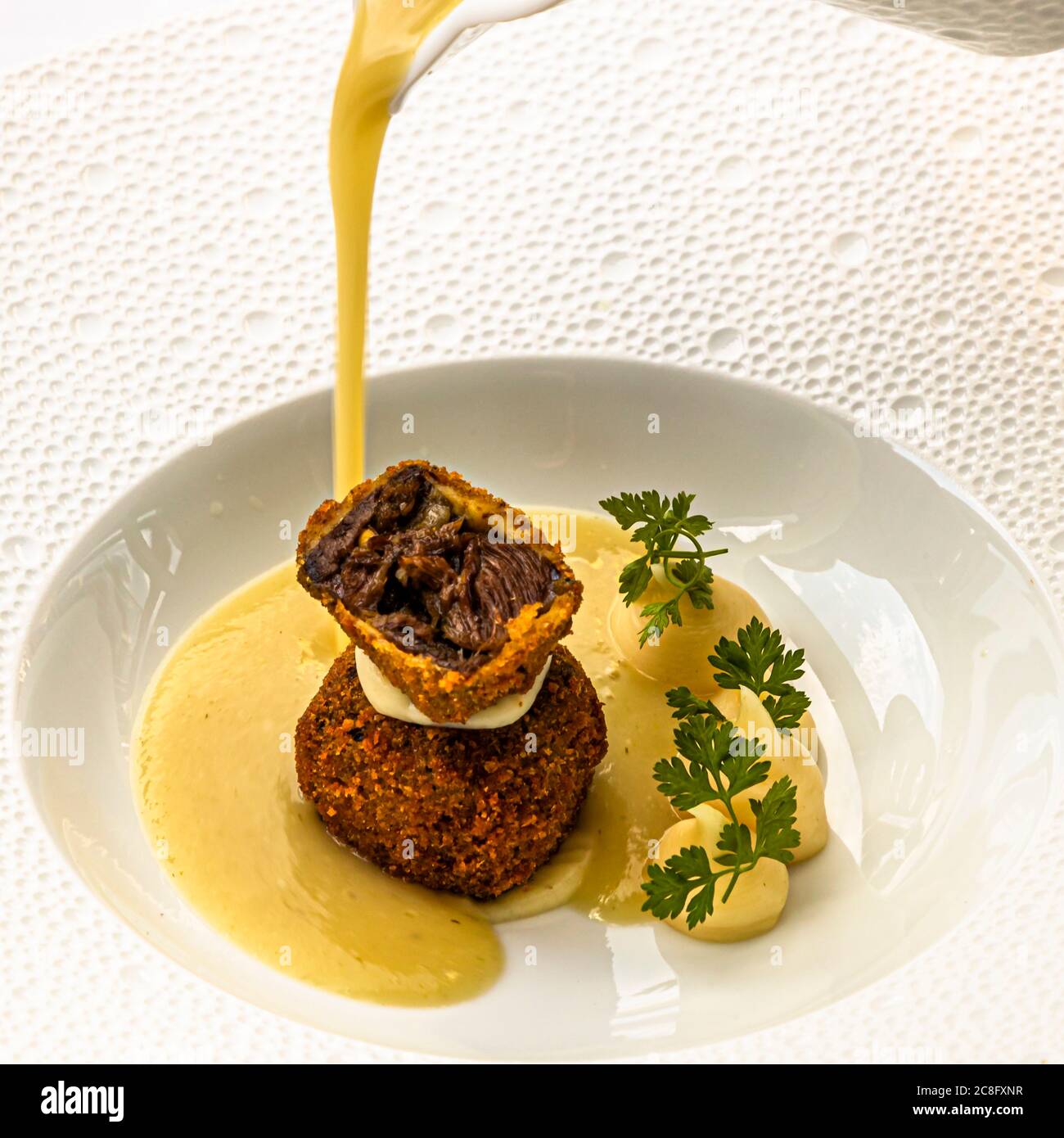 Plat gastronomique par Hotel Krone Chef de cuisine Peter Prüfer à Weil am Rhein, Allemagne. Deux types de tête de veau : la tête de Chalb maigre et cuite avec du velouté de panais et du cerfeuil Banque D'Images