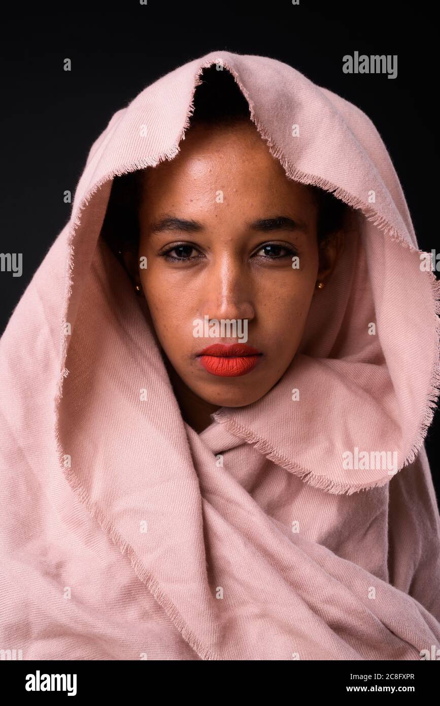 Jeune belle femme africaine avec cheveux afro sur fond noir Banque D'Images