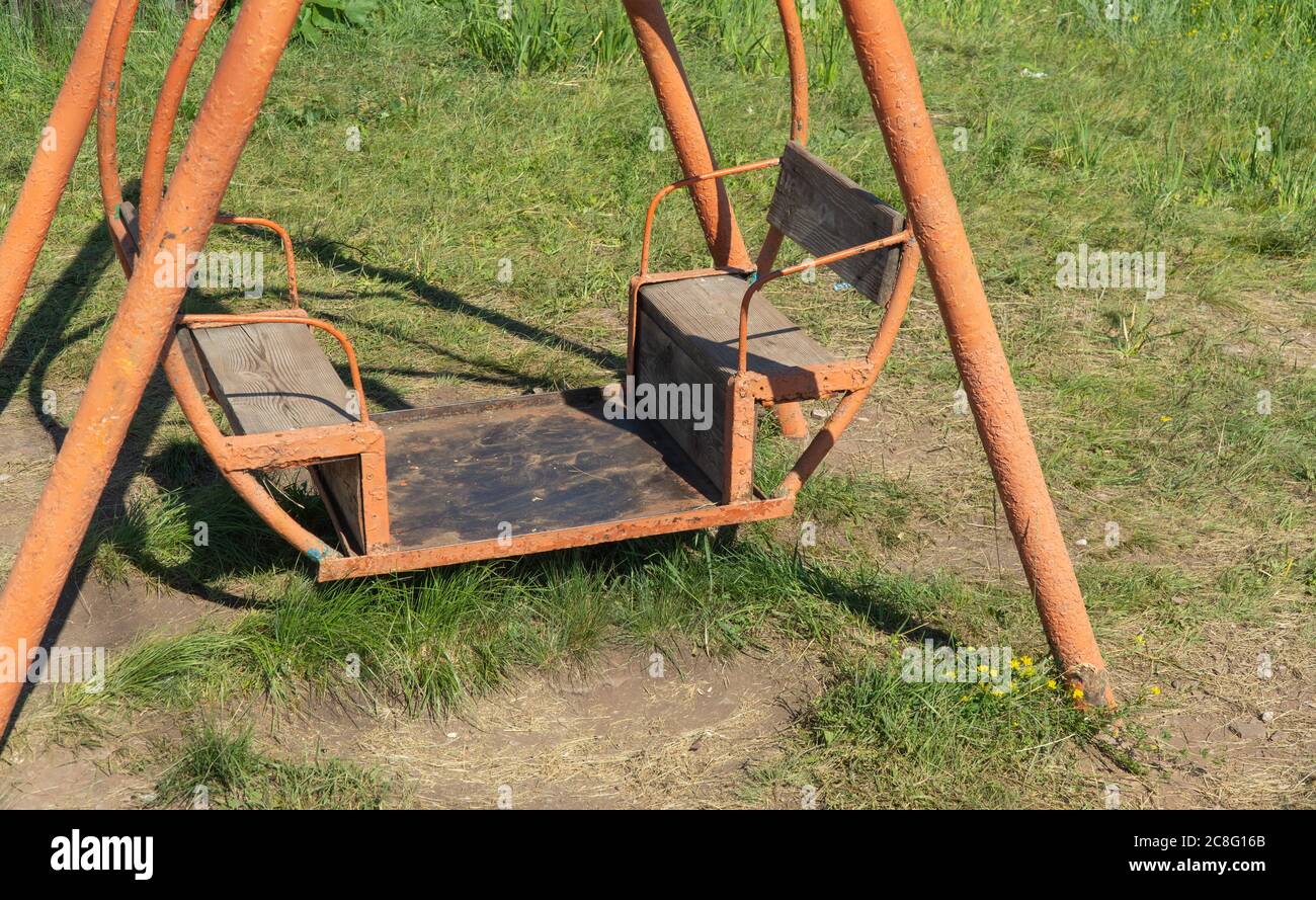 vieux rouillé balançoire sur l'herbe. balançoires vides, le concept d'enlèvement. Banque D'Images