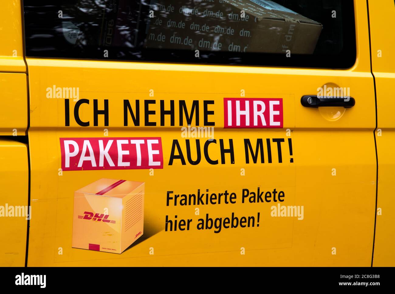 Porte d'un transporteur DHL indiquant que des colis sont transportés. (ICH nehme auch ihre Pakete mit) Banque D'Images