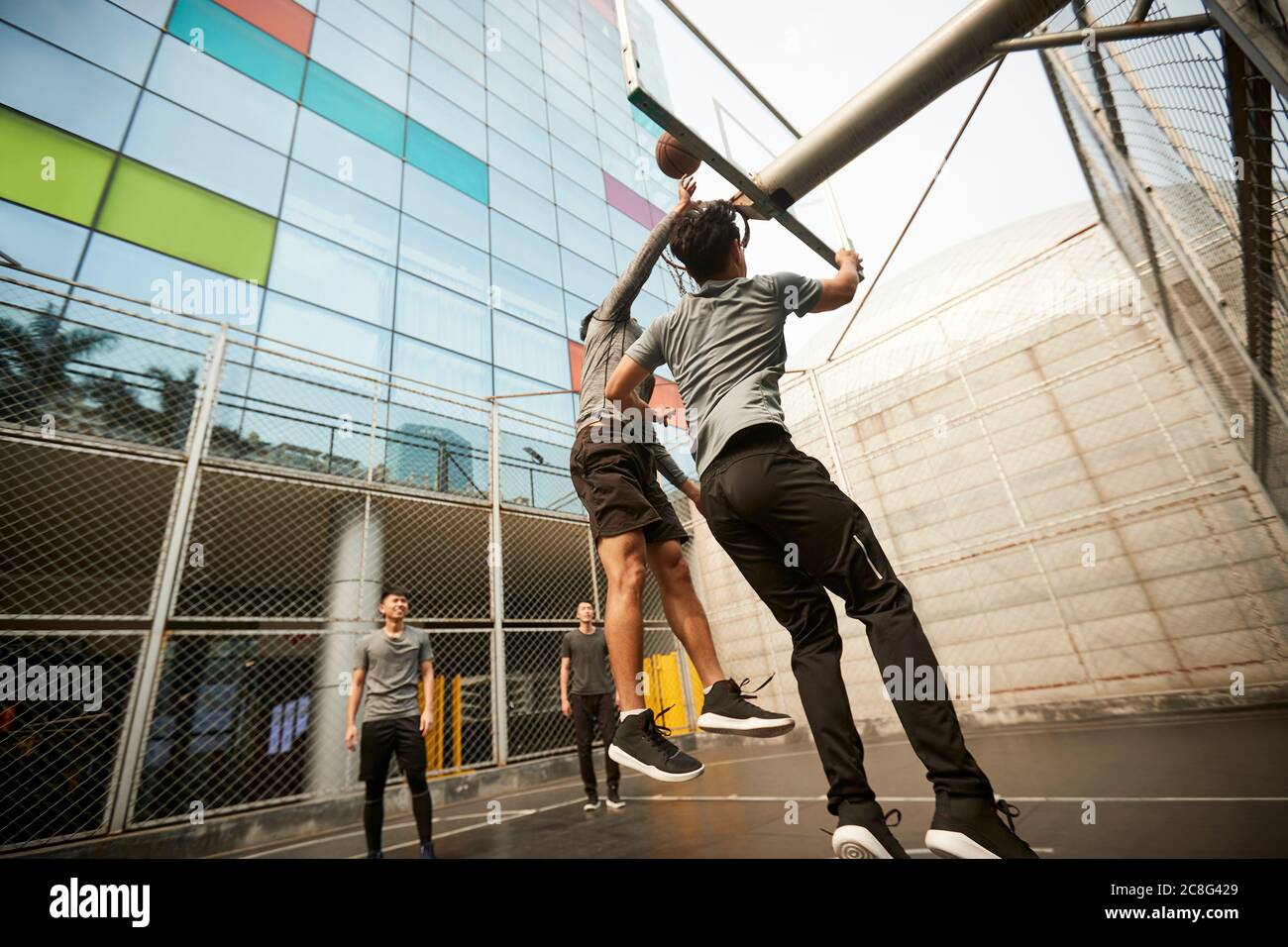 jeunes joueurs de basket-ball asiatiques adultes et hommes jouant au basket-ball sur un terrain extérieur Banque D'Images