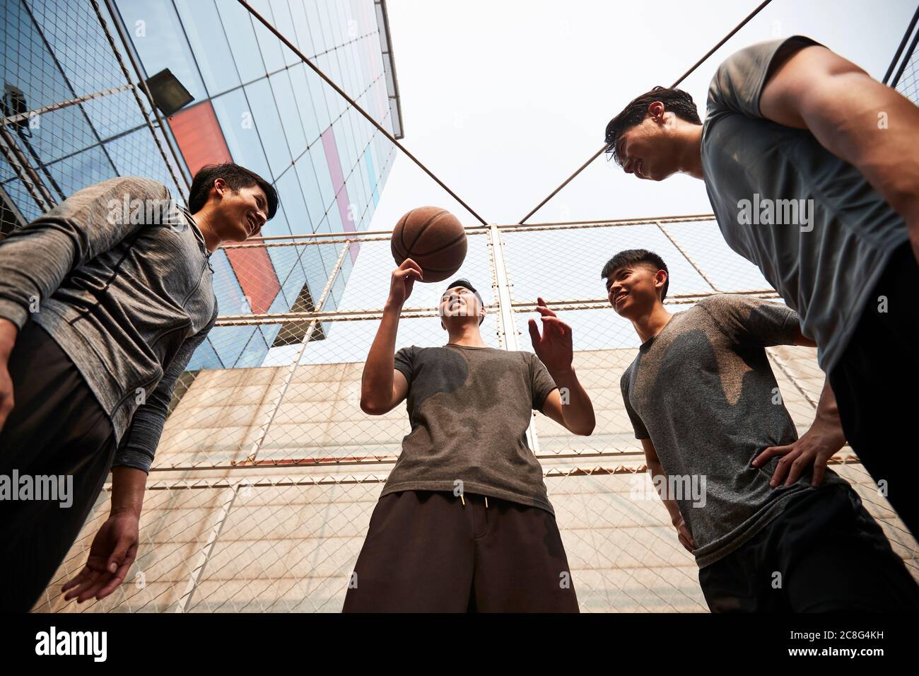 jeunes hommes adultes asiatiques s'amusant à jouer avec le basket-ball en plein air Banque D'Images