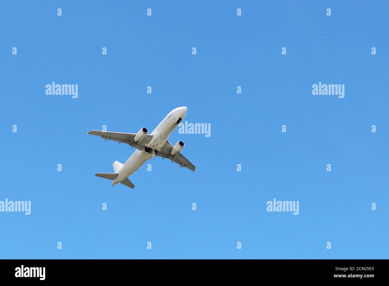 Vol d'un avion dans le ciel bleu clair, vue de dessous. Avion au décollage commercial Banque D'Images