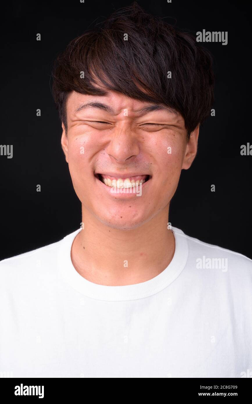 Beau jeune homme asiatique sur fond noir Banque D'Images