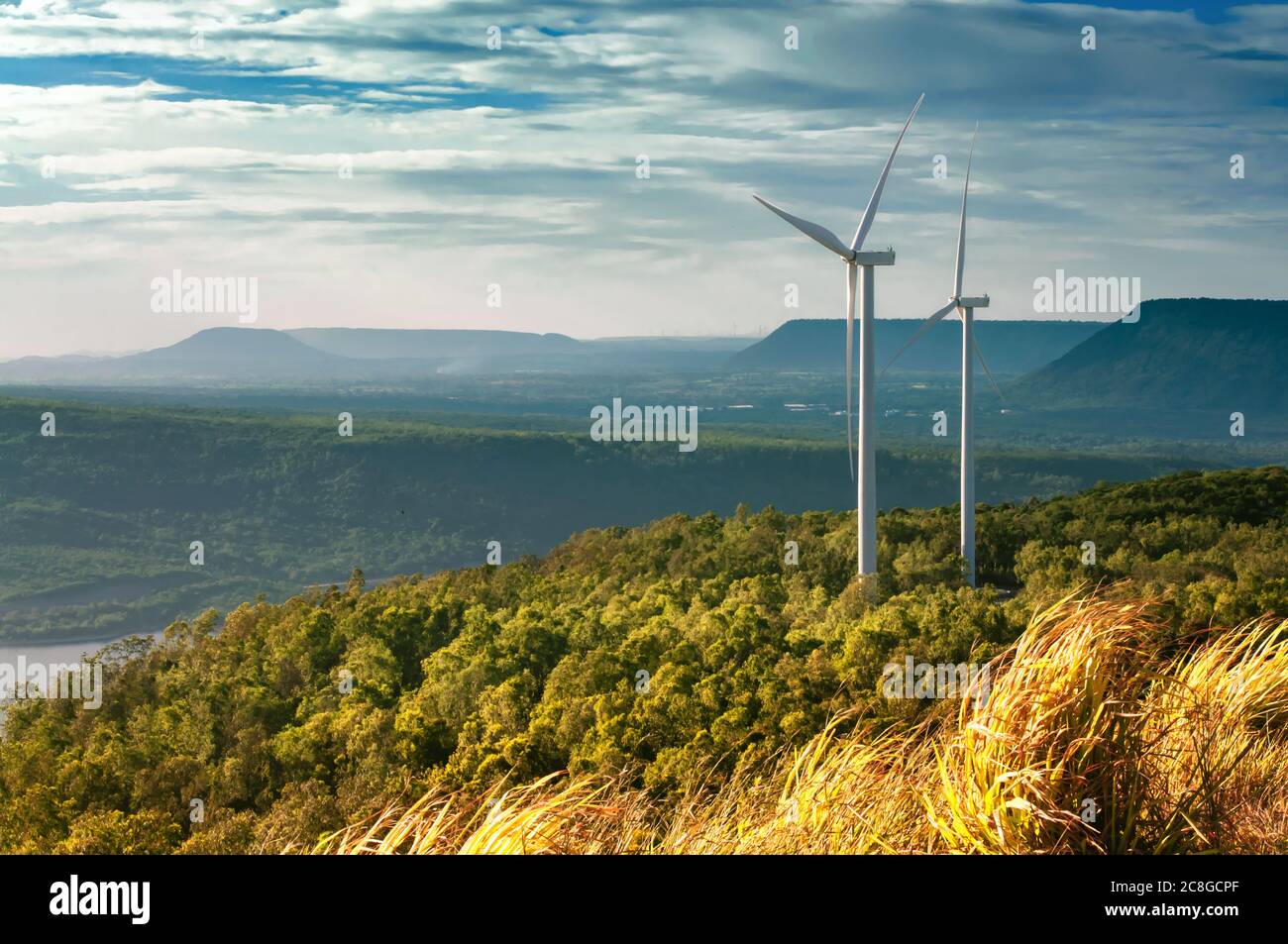 Éoliennes électriques au-dessus du barrage avec la montagne. Banque D'Images