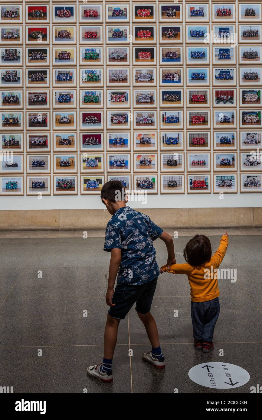 Londres, Royaume-Uni. 24 juillet 2020. Une famille (dont Lucian, 7 et Ivo, 19 mois) a un aperçu du projet d'écoles de l'année 3 de Steve McQueen dans la galerie Duveen - la Tate Britain rouvre à nouveau lundi. Les visiteurs sont invités à suivre les conseils sur la distanciation sociale, etc., conformément aux conseils du gouvernement après l'assouplissement du verrouillage. Crédit : Guy Bell/Alay Live News Banque D'Images