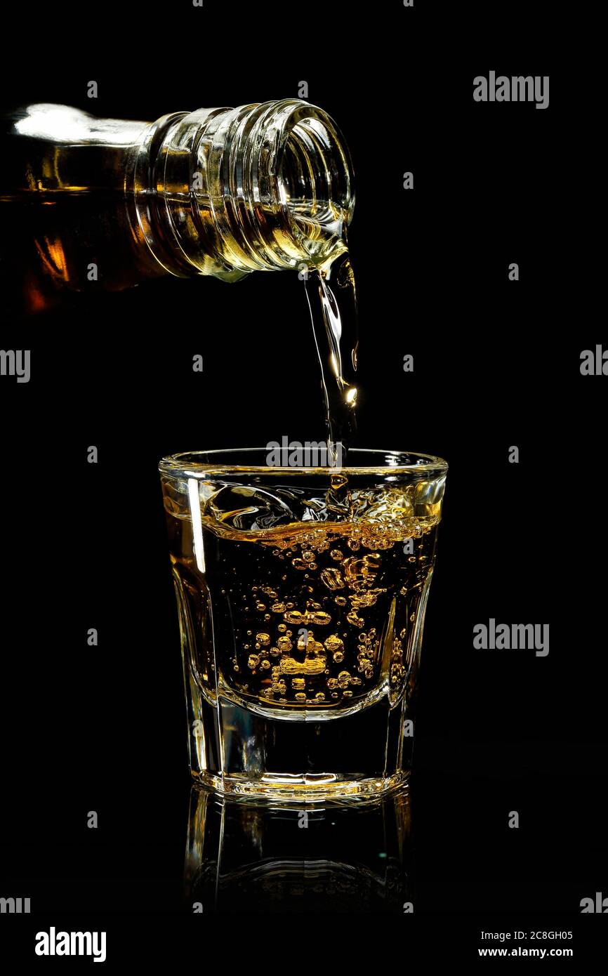 verser le whisky dans un verre à plomb contre le noir Banque D'Images