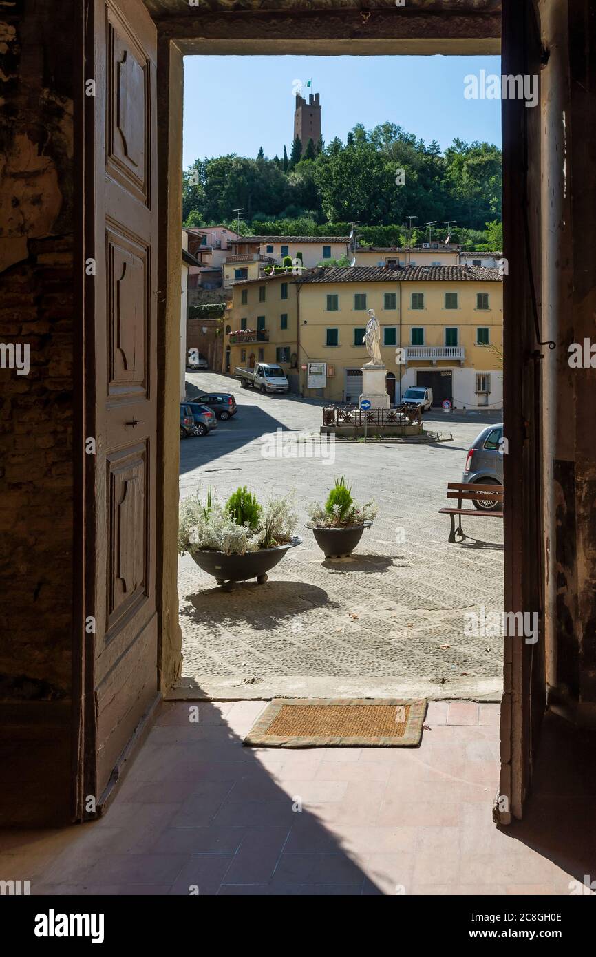 Piazza Buonaparte et la tour de Rocca Federico II encadrées par la porte de l'oratoire des Saints Sebastian et Rocco, San Miniato, Italie Banque D'Images