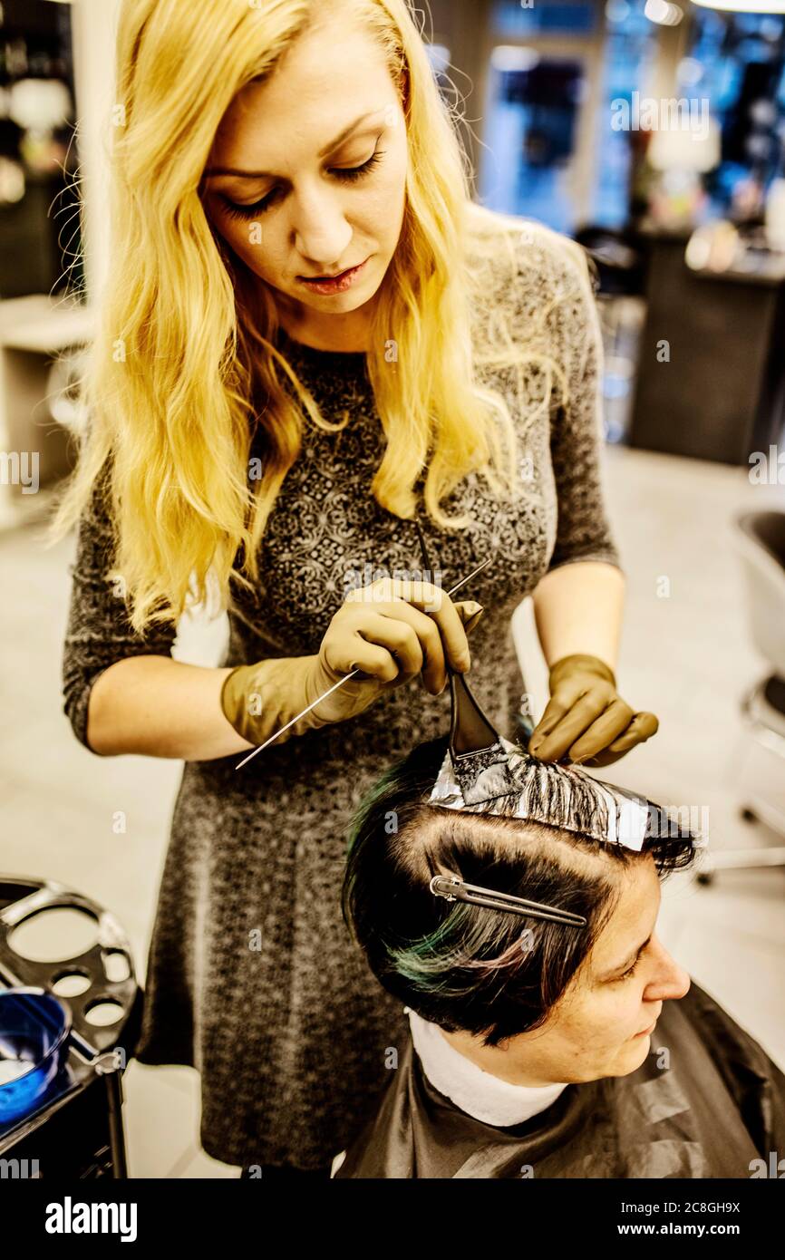 Coiffeur dans un salon de coiffure, avec des mèches de cheveux en aluminium, Cologne, Rhénanie-du-Nord-Westphalie, Allemagne Banque D'Images