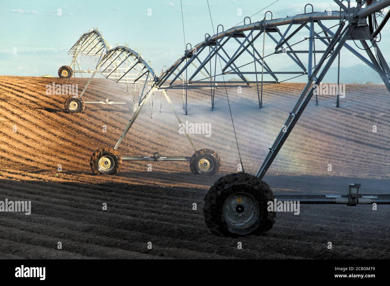 Un arroseur à pivot de centre agricole utilisé pour irriguer des rangées de pommes de terre dans un champ des champs fertiles de l'Idaho. Banque D'Images