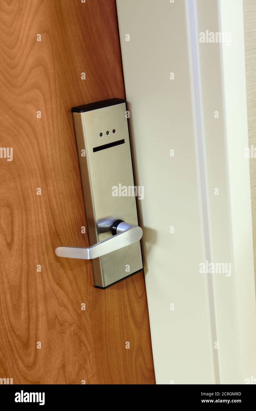 Une serrure de porte moderne à carte-clé sur la porte d'une chambre d'hôtel, avec une carte-clé insérée. Banque D'Images