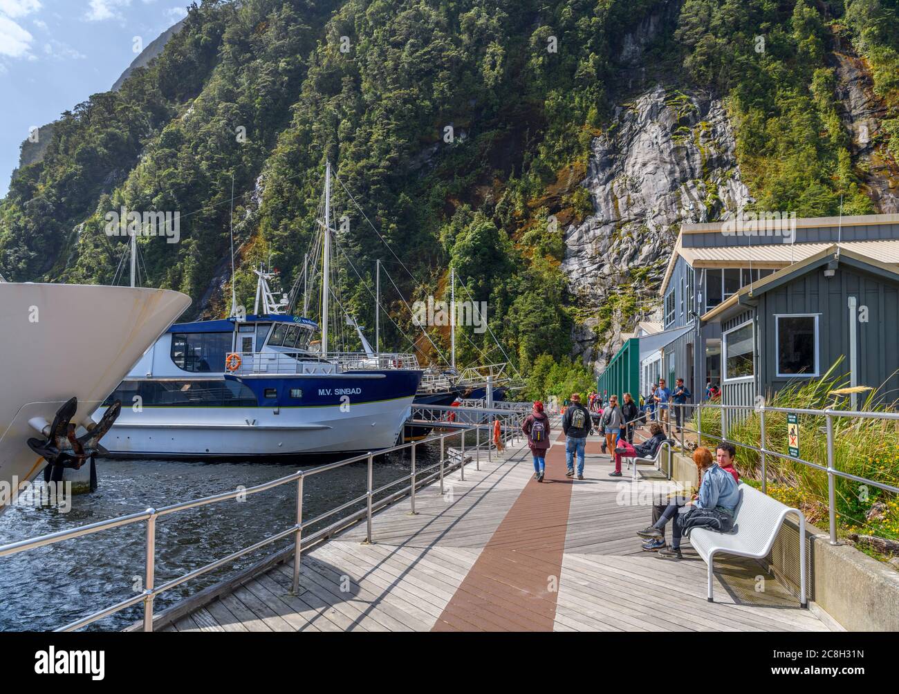 Des bateaux de croisière amarrés devant le centre d'accueil des visiteurs à Milford Sound, parc national Fiordland, Southland, South Island, Nouvelle-Zélande Banque D'Images