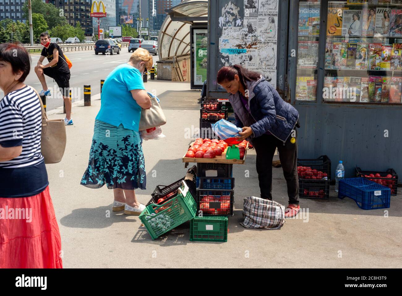 Une femme tzigane vendait des tomates dans une cabine impromptue sur le trottoir à l'arrêt de bus très fréquenté de Sofia Bulgarie comme commerce illégal dans l'environnement urbain Banque D'Images