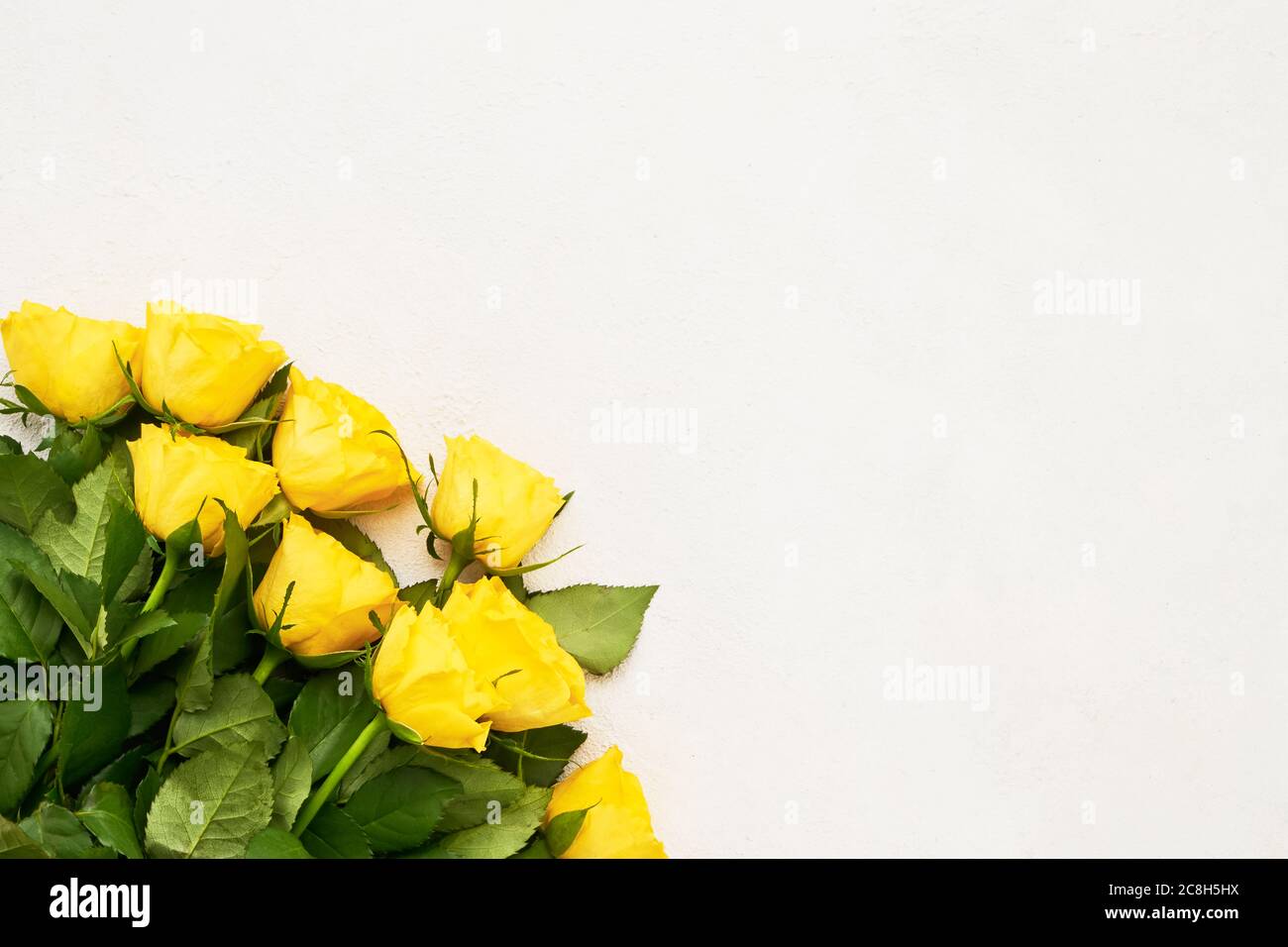 Bouquet de roses jaunes sur fond clair. Concept de fête des mères, de fête de la Saint-Valentin, de célébration d'anniversaire. Copier l'espace pour le texte, vue de dessus Banque D'Images