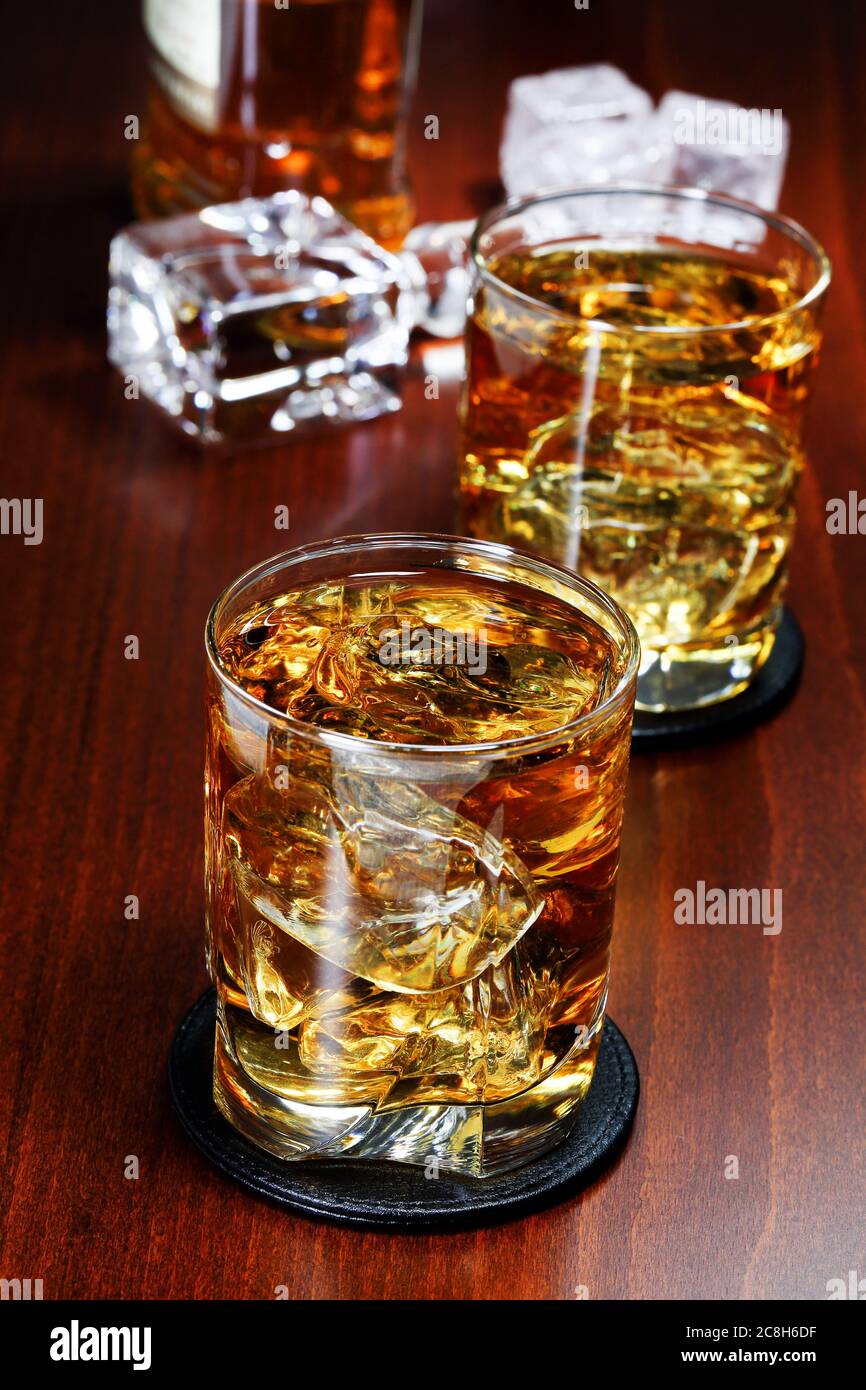 deux verres de whisky avec glace sur une surface en bois Banque D'Images