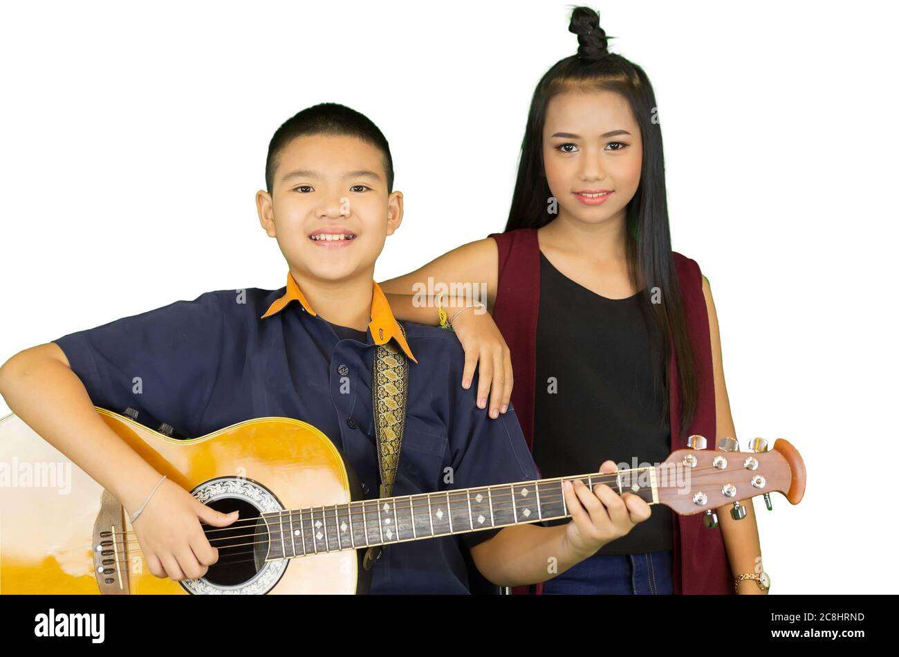 Portrait d'une paire d'élèves asiatiques du primaire, hommes et femmes, avec guitare dans une salle de classe musicale. Banque D'Images