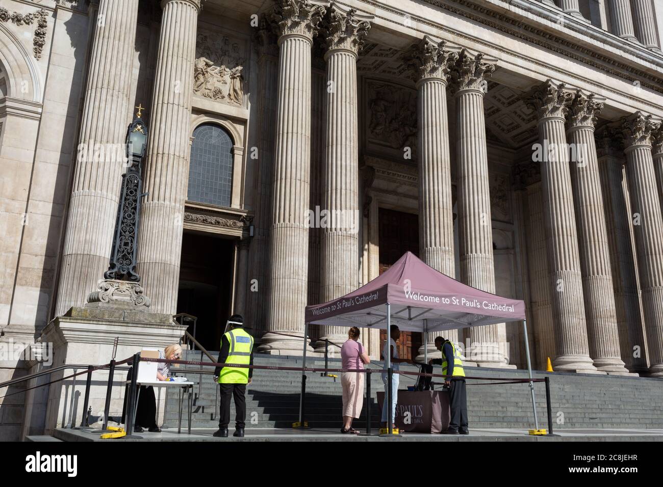 Les visiteurs de la cathédrale Saint-Paul subissent des contrôles de sécurité, en remplissant leurs coordonnées et d'autres renseignements personnels pendant la pandémie du coronavirus dans la ville de Londres, le 20 juillet 2020, à Londres, en Angleterre. Les coordonnées peuvent être utilisées pour suivre et tracer ceux qui ont pu être proches de toute personne qui s'est révélée infectée par Covid. Banque D'Images