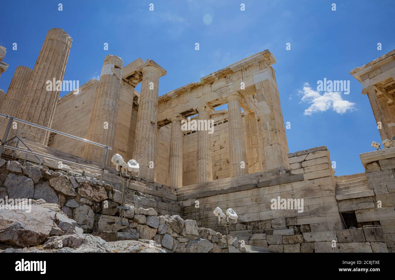 Athènes Acropole, site touristique de la Grèce. Porte d'entrée de Propylaea vide, colonnes et escaliers grecs anciens, vue à angle bas, ciel bleu nuageux. Banque D'Images