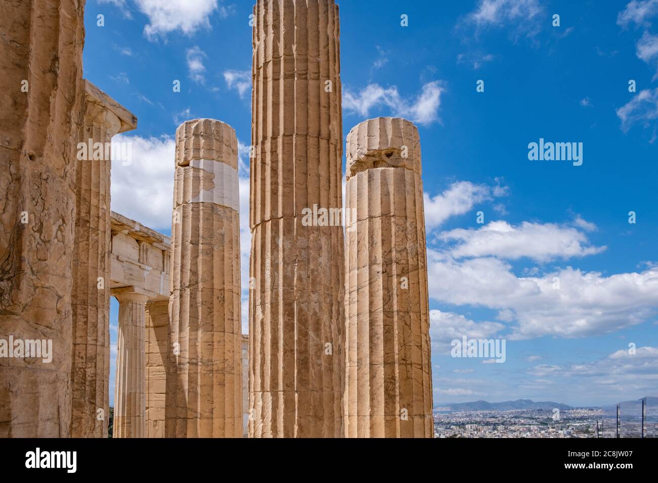 Athènes Acropole, site touristique de la Grèce. Colonnes grecques anciennes piliers à la porte d'entrée de Propylaea, vue sur la ville et ciel bleu nuageux. Banque D'Images