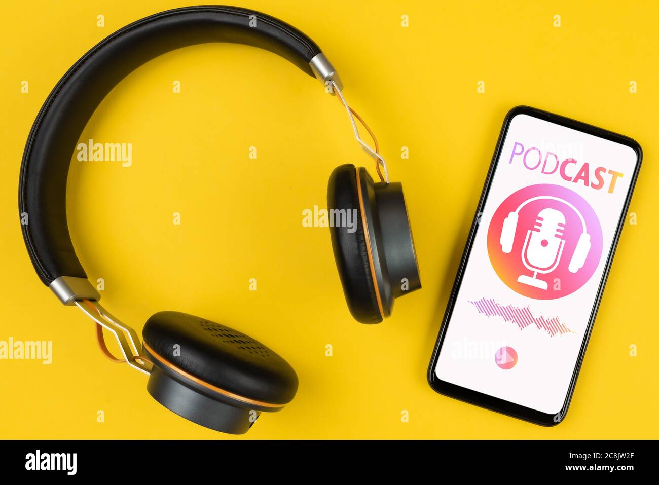 concept de baladodiffusion, vue au-dessus des écouteurs et du smartphone avec maquette de balado sur fond jaune Banque D'Images
