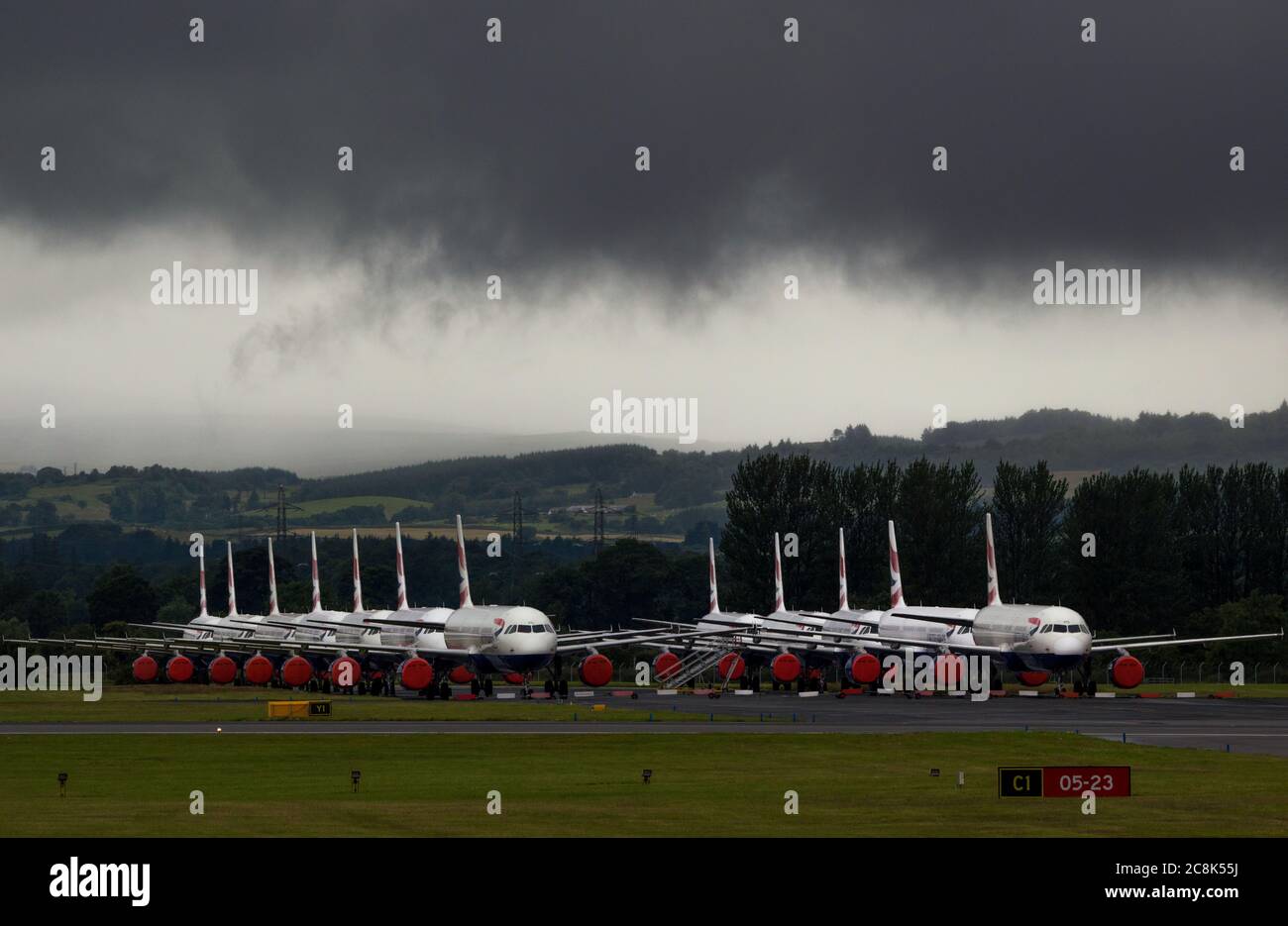 Glasgow, Écosse, Royaume-Uni. 23 juillet 2020. Photo : sous un nuage sombre menaçant, les Airbus A319/A320/A321 de British Airways (BA) sont installés sur la deuxième piste de l'aéroport de Glasgow en attendant leur sort de vente ou de stockage. Depuis mars, ces avions sont inactifs sur le tarmac des aéroports, doe à la crise mondiale du coronavirus (COVID19). British Airways a réduit ses effectifs de près de 12,000 personnes et a jusqu'à présent retiré toute sa flotte Boeing 747 pour réduire ses coûts d'exploitation. Crédit : Colin Fisher/Alay Live News. Banque D'Images