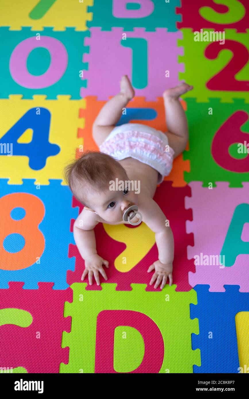 Vue de bébé depuis le dessus sur un tapis de jeu en mousse Banque D'Images