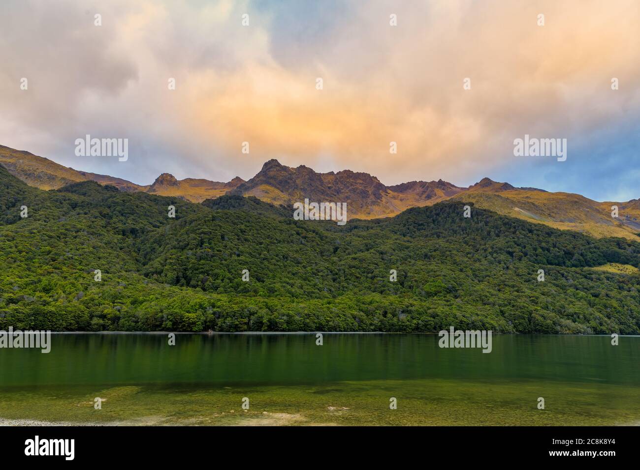 Forêts et montagnes entourant le lac Mavora Nord au coucher du soleil par une journée nuageux. Banque D'Images