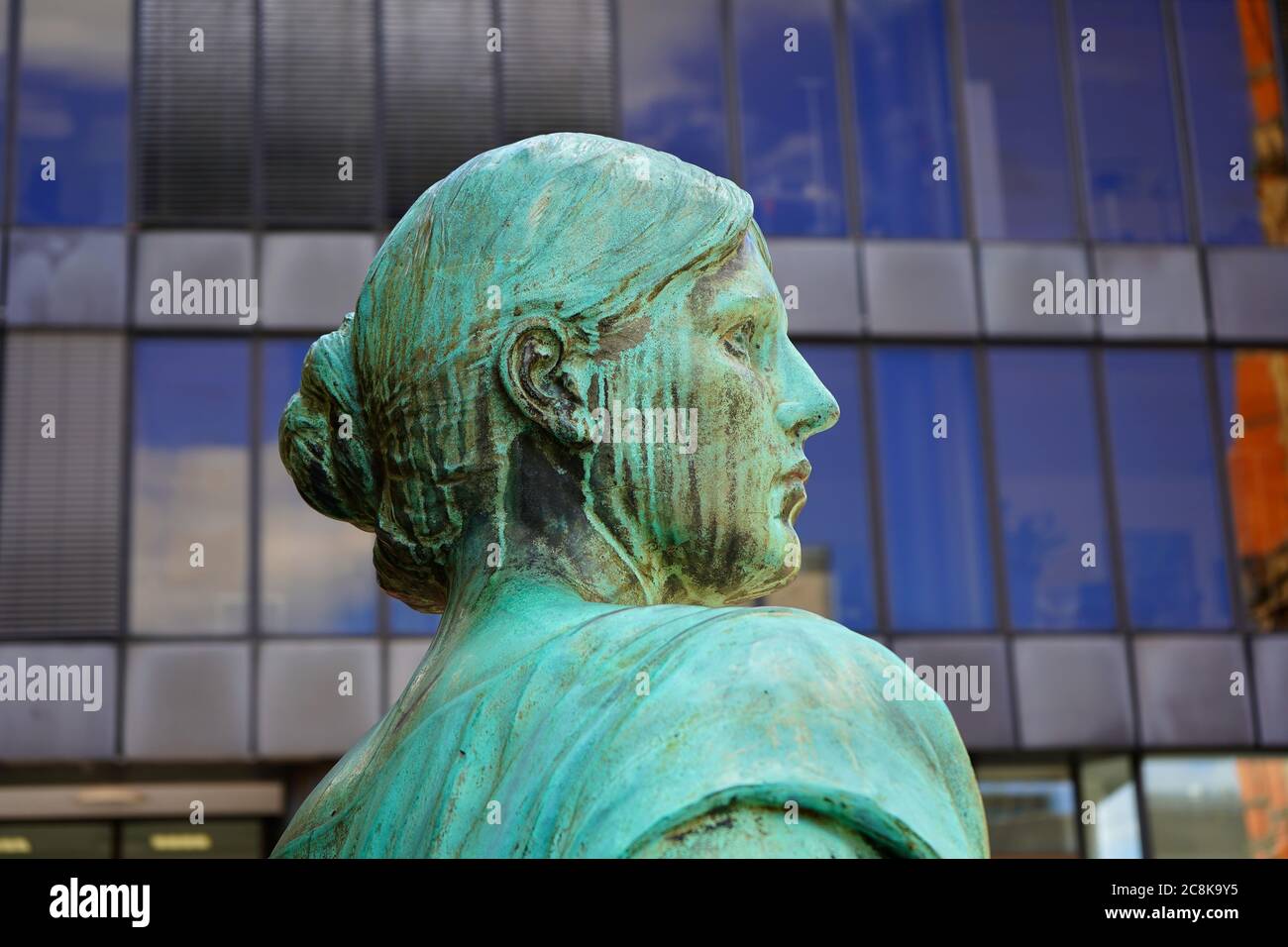 Ancienne sculpture en bronze d'une femme, partie allégorique du monument de Bismarck à Düsseldorf, dévoilée en 1899. Devant un immeuble de bureaux moderne. Banque D'Images