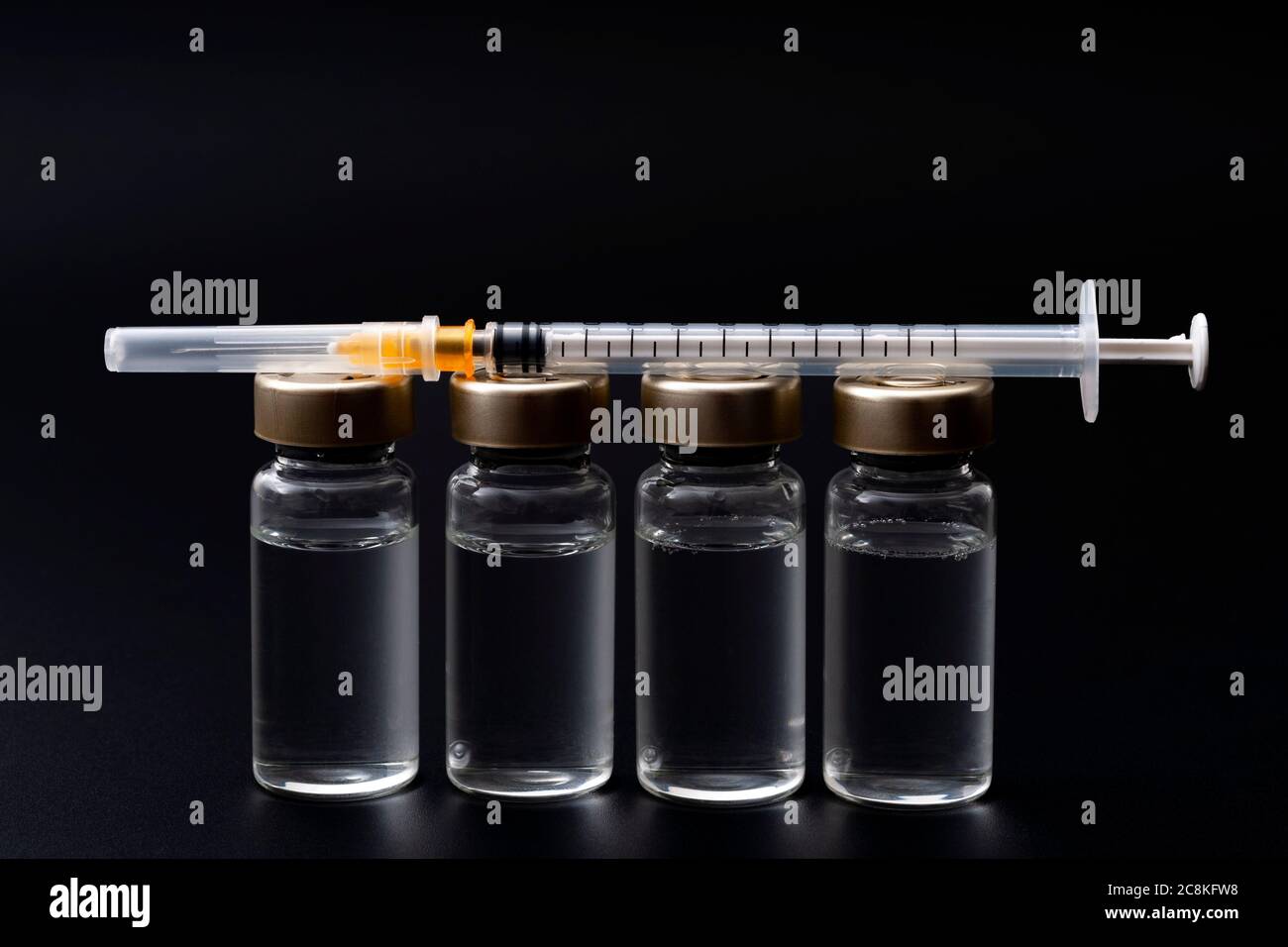 Vaccins, toxine botulinique et ampoules d'insuline concept thème avec des flacons en verre avec liquide clair à côté d'une seringue et une aiguille hypodermique isolée sur b Banque D'Images