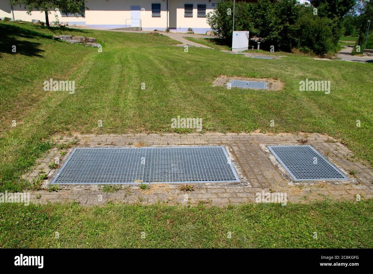 La grille métallique pour pénétrer dans un bassin de rétention d'eau de pluie a été fixée avec un verrou Banque D'Images