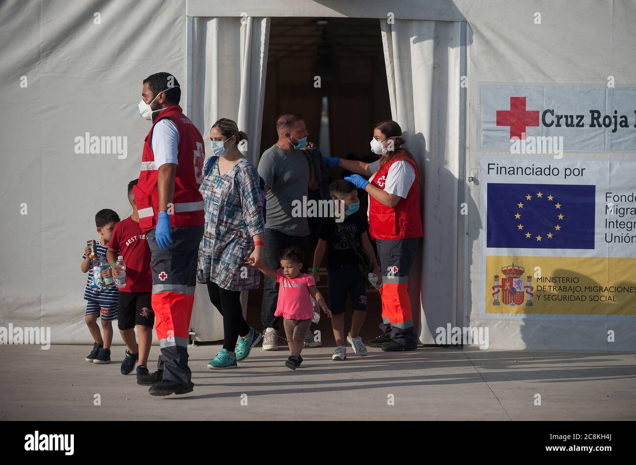 Les migrants algériens quittent une tente de la Croix-Rouge espagnole tout  en portant un masque facial après avoir été interceptés par les autorités  de la Garde civile espagnole sur la Méditerranée.UN navire