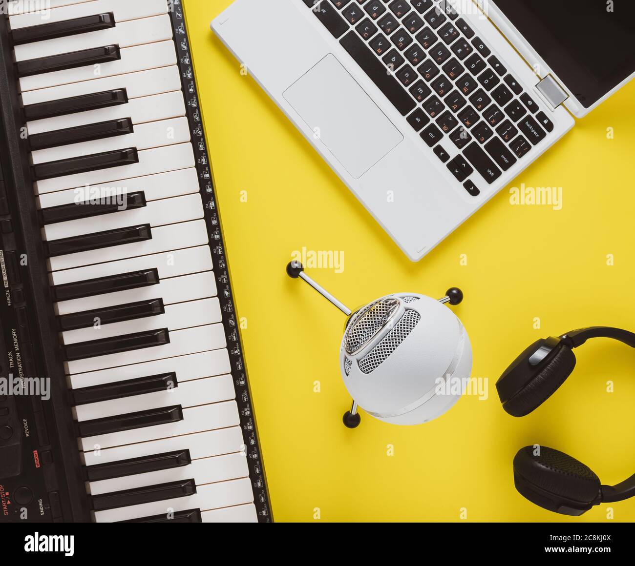 Objets liés aux leçons de piano en ligne : clavier, microphone et ordinateur portable. Banque D'Images
