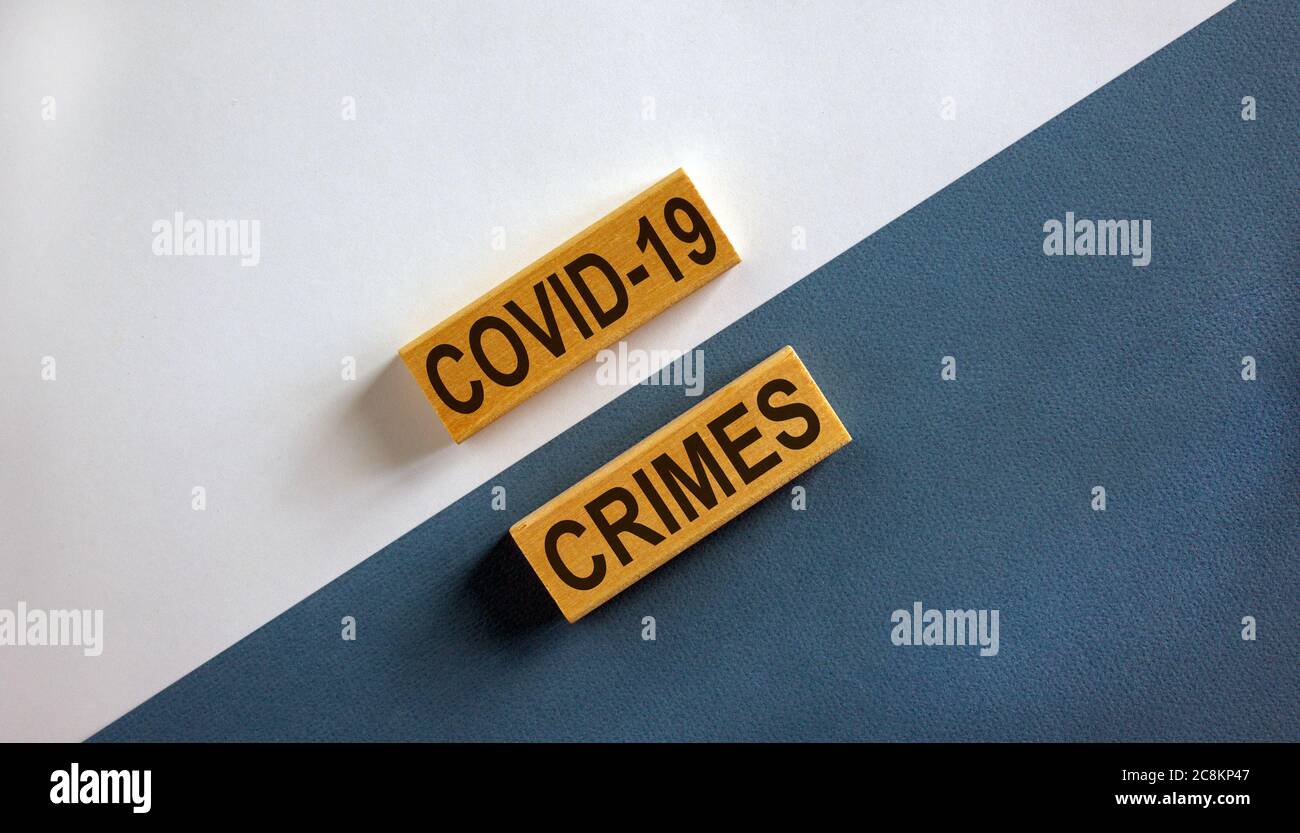 Mots « Covid-19 crimes » sur des blocs de bois. Concept d'entreprise. Magnifique fond blanc et bleu. Banque D'Images