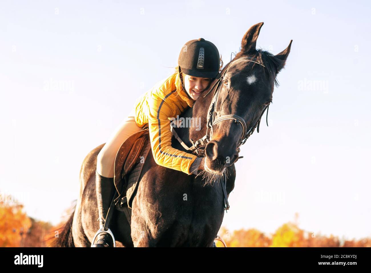 Adolescente équestrienne embrassant son joli cheval. Image horizontale d'été éclatante en extérieur avec filtre. Banque D'Images