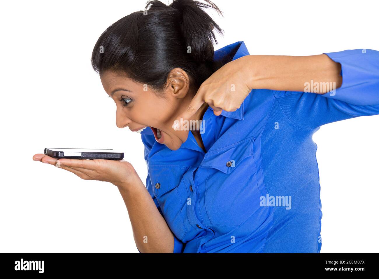 Portrait d'une jeune femme en colère hurle alors qu'elle était sur un téléphone isolé sur fond blanc. Banque D'Images