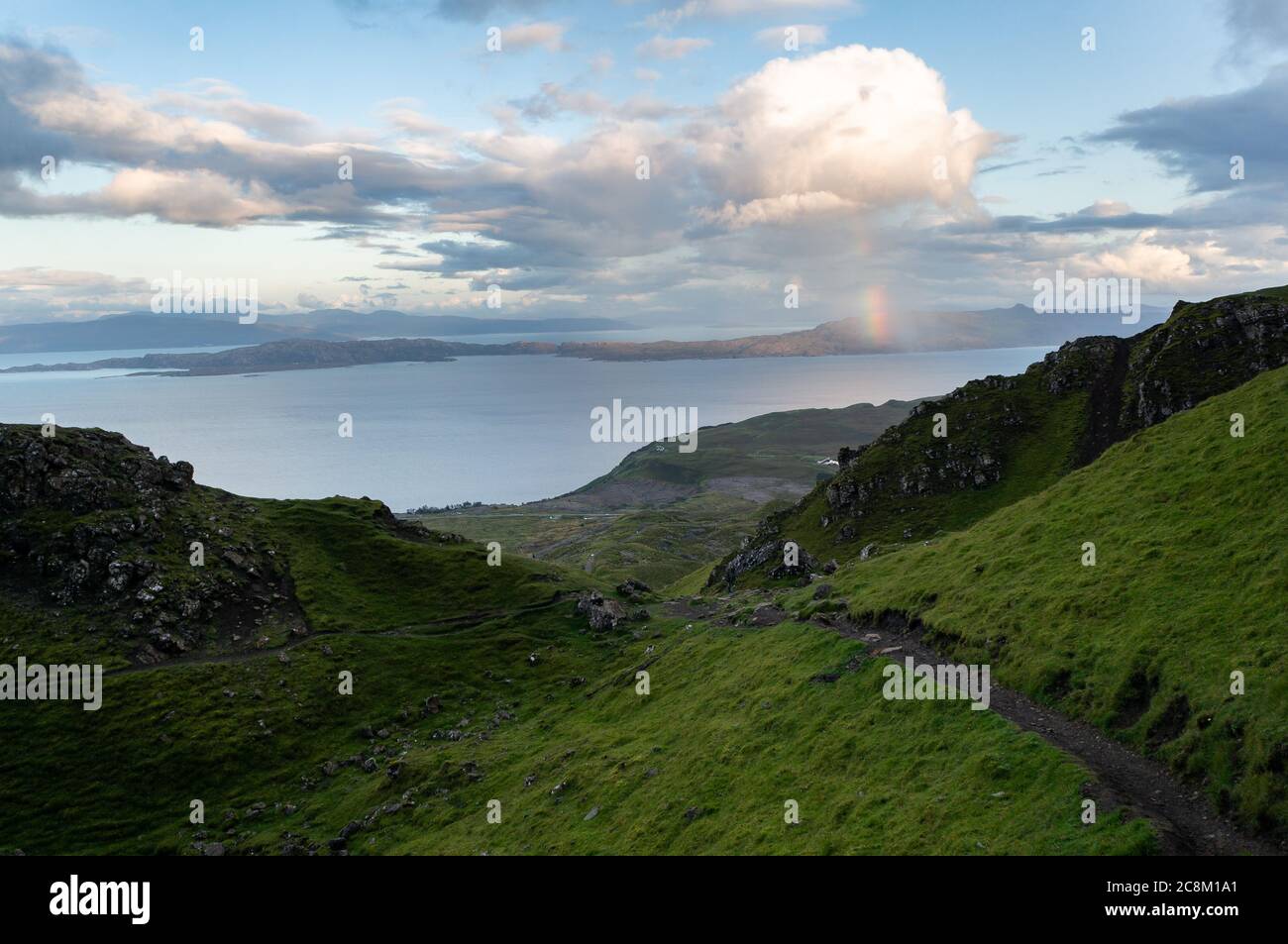 Un arc-en-ciel au-dessus des montagnes au loin. Sentier de randonnée jusqu'au majestueux sommet rocheux du Old Man of Storr. Banque D'Images