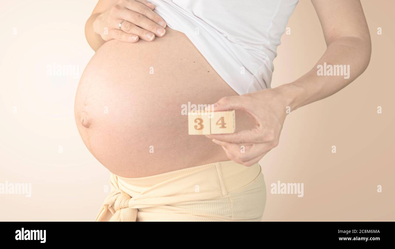 Jeune Femme Enceinte Avec Numero De Semaine De Grossesse A Cote De Son Ventre Photos De La Croissance Du Ventre A 34 Semaines De Grossesse Alimentation Saine Pendant La Grossesse Photo Stock