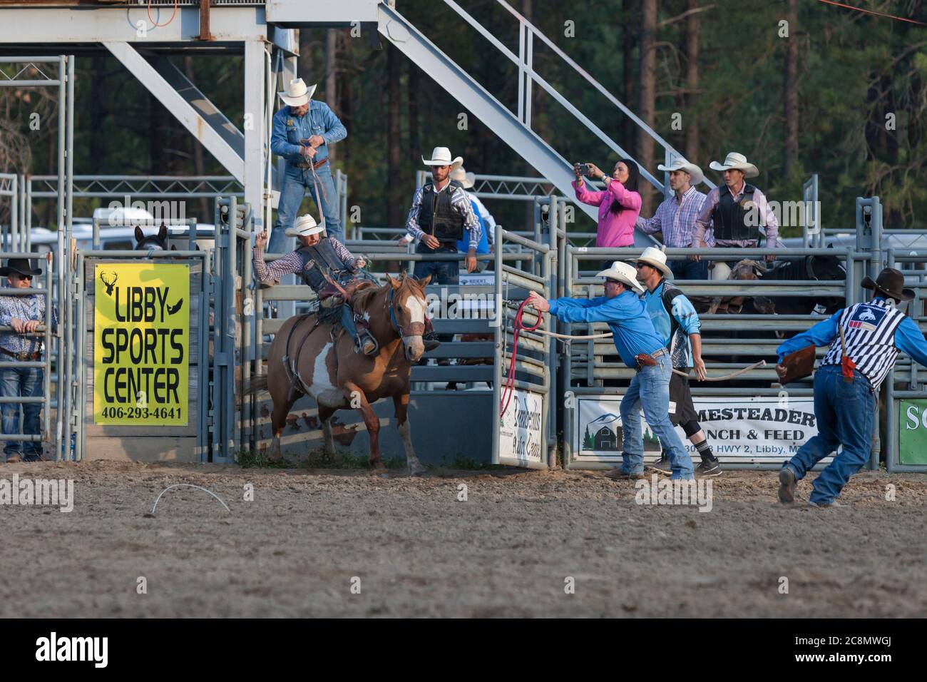 Un cowboy participe à l'épreuve de bronze de selle au Kootenai River Stampede à Libby, Montana, le vendredi 24 juillet 2020. Le rodéo annuel a été organisé avec des mesures de sécurité supplémentaires en place en raison de la montée des cas de COVID-19 dans l'État. Banque D'Images