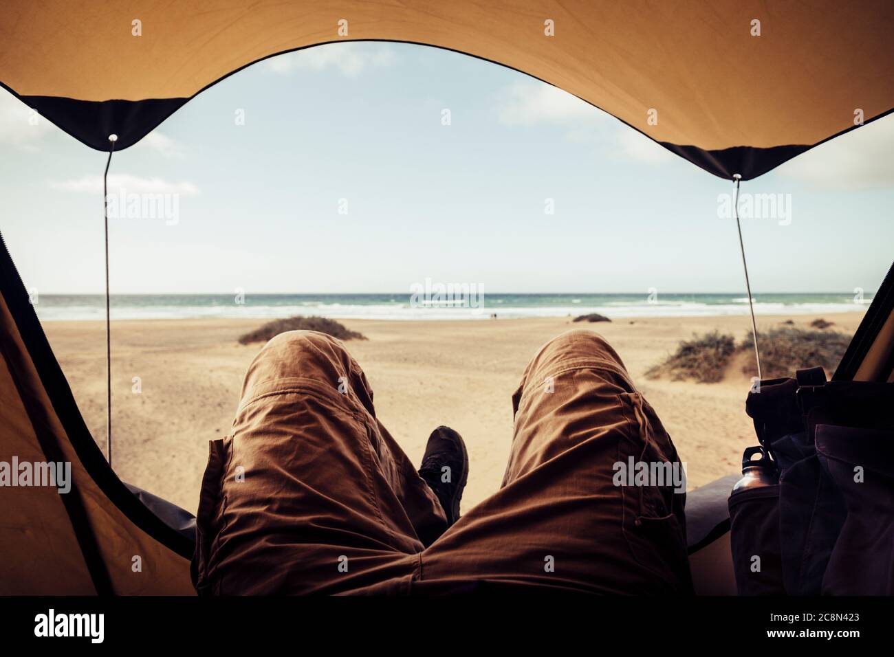 Détendez-vous et profitez de vacances d'été en camping tente sur une vue gratuite sur la plage du désert - homme méconnaissable couché et profiter à l'intérieur du petit t Banque D'Images