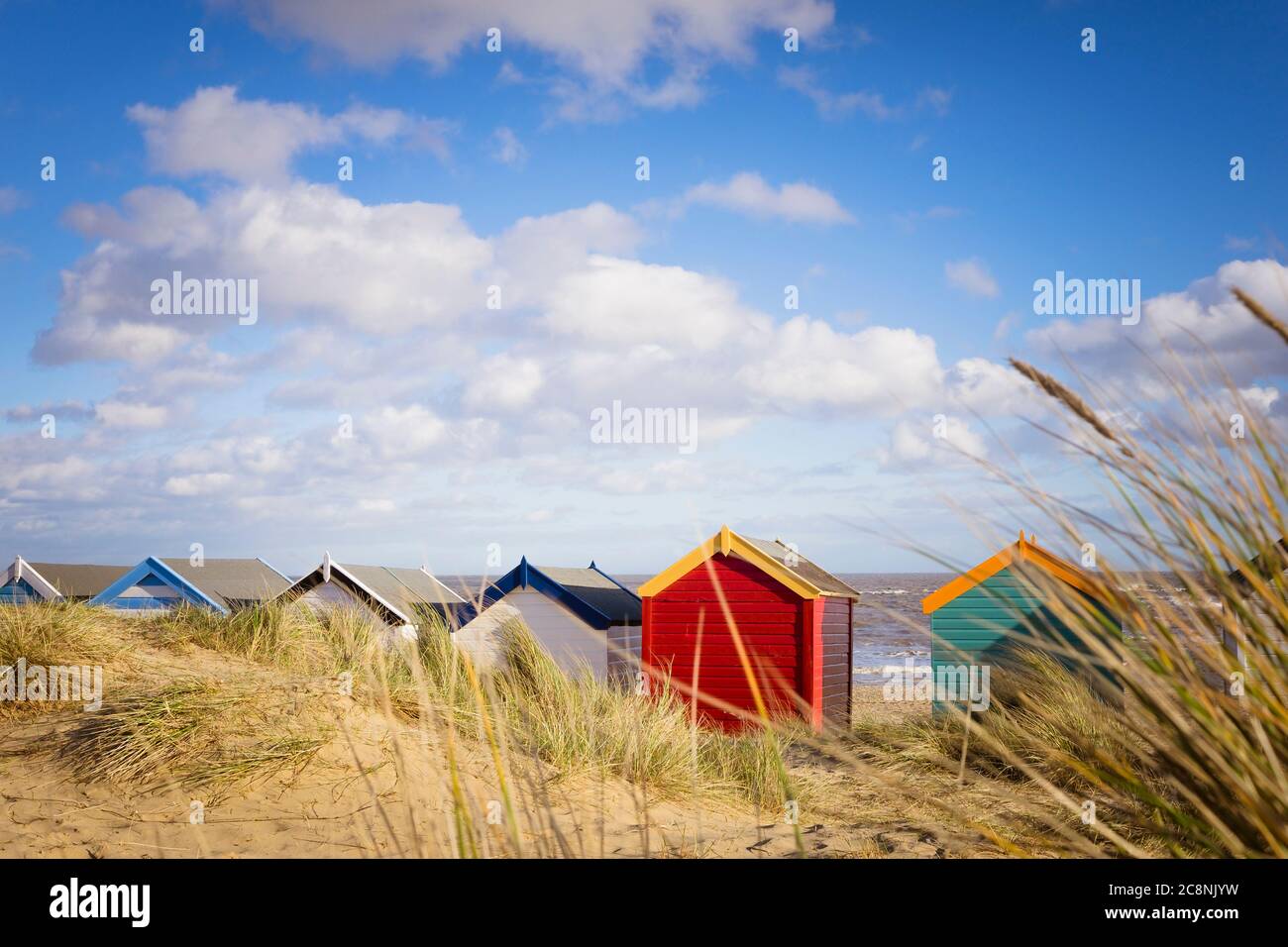 Southwold plage huttes à travers les dunes herbeuses. Banque D'Images