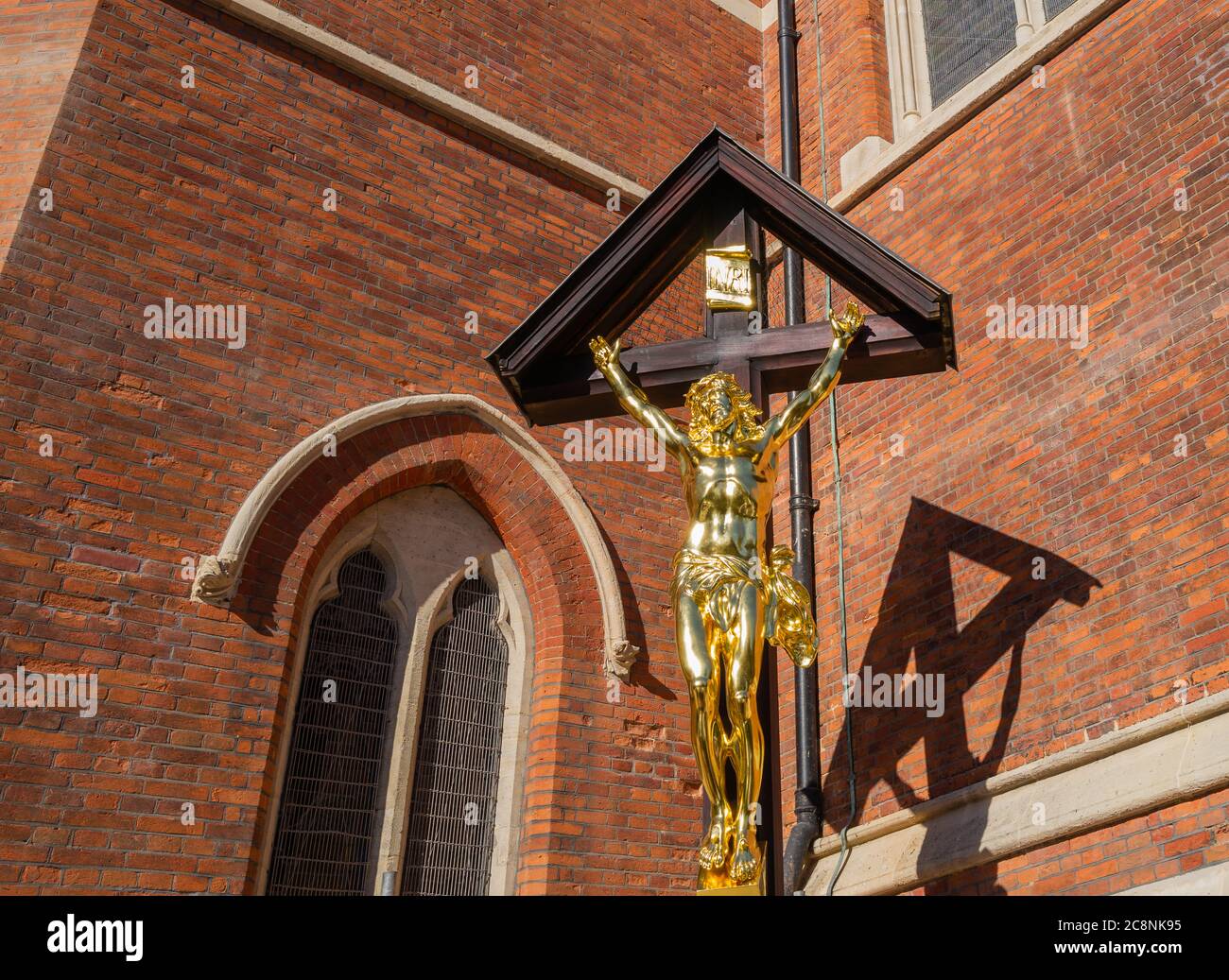 L'église St Mary Magdalene de Paddington, Londres, s'est achevée dans les années 1870 dans un bidonville dense. Mémorial de la première Guerre mondiale du Christ (fonte et doré) sur croix en bois. Banque D'Images